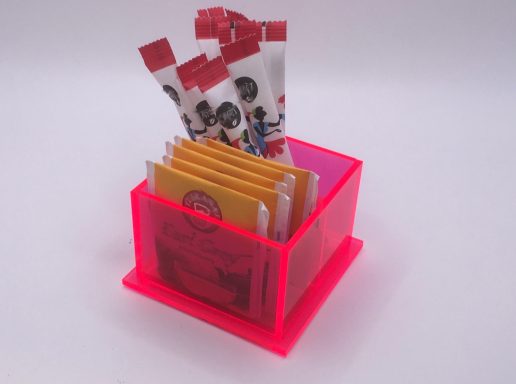 Ein leuchtend pinkfarbener Behälter mit verschiedenen Gewürzpackungen.